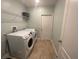 Functional laundry room with side-by-side washer and dryer and overhead shelving at 878 Benjamin Trl, Davenport, FL 33837
