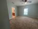 Spacious main bedroom with carpet, a ceiling fan, and a view into the bathroom at 878 Benjamin Trl, Davenport, FL 33837