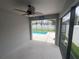 A covered patio with fan looks out to the sparkling pool and fenced backyard at 878 Benjamin Trl, Davenport, FL 33837
