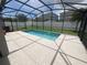 A refreshing screened-in pool is surrounded by a patio, offering a private outdoor space for relaxation and recreation at 878 Benjamin Trl, Davenport, FL 33837