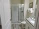 Well-lit bathroom featuring a glass door shower and modern vanity with granite countertop at 9079 Dogleg Dr, Davenport, FL 33896
