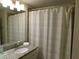 Bathroom with a modern vanity, granite countertop, and a shower with a white curtain at 9079 Dogleg Dr, Davenport, FL 33896