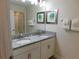 Bathroom features double sinks with granite countertops and decorative art for a spa-like experience at 9079 Dogleg Dr, Davenport, FL 33896