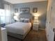 Cozy bedroom with blue walls, plush carpet, comfortable queen bed and stylish lamps at 9079 Dogleg Dr, Davenport, FL 33896