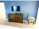 Stylish bedroom features a modern dresser, wall-mounted TV, and elegant chair for a contemporary look at 9079 Dogleg Dr, Davenport, FL 33896