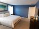 Bedroom with a king bed, neutral bedding, a large window, and stylish decor at 9079 Dogleg Dr, Davenport, FL 33896