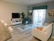 Bright living room featuring modern furniture, a large TV, and access to the outdoors at 9079 Dogleg Dr, Davenport, FL 33896