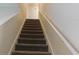 Carpeted staircase leading to the upper level of the house with white railing at 9079 Dogleg Dr, Davenport, FL 33896