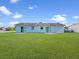 Large backyard features sliding glass doors and an expansive lawn at 98 Pinata Ct, Kissimmee, FL 34743