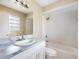 This bathroom features a vanity with marble counters, a large mirror and shower and tub combo at 98 Pinata Ct, Kissimmee, FL 34743