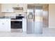 Modern kitchen featuring stainless steel appliances including a refrigerator and oven, complemented by granite countertops at 98 Pinata Ct, Kissimmee, FL 34743