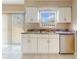 The kitchen features white cabinets, tile flooring, stainless steel dishwasher, and a double stainless steel sink at 98 Pinata Ct, Kissimmee, FL 34743