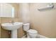 Cozy half bathroom features a pedestal sink, toilet, and a convenient shelf at 1002 Chalcedony St, Kissimmee, FL 34744