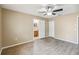 Bedroom featuring modern ceiling fan, wood-look floors, and door to en-suite bathroom at 1002 Chalcedony St, Kissimmee, FL 34744