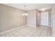 Dining area with ceramic tile floors, chandelier, and door to the home's entrance at 1002 Chalcedony St, Kissimmee, FL 34744