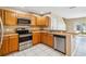 Kitchen featuring wood cabinets, stainless steel appliances, and a breakfast bar at 1002 Chalcedony St, Kissimmee, FL 34744