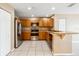 Kitchen featuring stainless steel appliances, wood cabinetry, and a breakfast bar at 1002 Chalcedony St, Kissimmee, FL 34744
