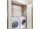 Modern laundry area with a full size washer and dryer and storage shelves at 1002 Chalcedony St, Kissimmee, FL 34744