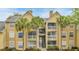 Condo exterior features multiple balconies, palm trees, and convenient stair access at 1065 S Hiawassee Rd # 1425, Orlando, FL 32835