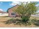 Backyard view showing the house with a screened in patio and a large yard with mature landscaping at 115 Anzio Dr, Kissimmee, FL 34758