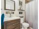 Bathroom featuring stylish wooden vanity, decorative mirror, and shower with neutral-toned tile at 115 Anzio Dr, Kissimmee, FL 34758