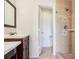 Bathroom view featuring a vanity with tiled shower and glass door beyond a door at 115 Anzio Dr, Kissimmee, FL 34758