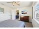 Bedroom view including ceiling fan, wood-look flooring, tv, and access to kitchen at 115 Anzio Dr, Kissimmee, FL 34758