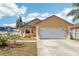 Charming tan home featuring a two-car garage, a well-maintained lawn, and a beautiful blue sky at 115 Anzio Dr, Kissimmee, FL 34758