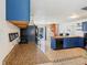 Kitchen with blue cabinets, tan countertops, black appliances and access to a spiral staircase at 115 Anzio Dr, Kissimmee, FL 34758