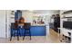 Bright kitchen features blue cabinetry, stainless appliances, breakfast bar with seating, and open layout at 115 Anzio Dr, Kissimmee, FL 34758
