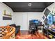 Room featuring black ceiling, hardwood floors, dark sofa, desk, and gaming setup at 115 Anzio Dr, Kissimmee, FL 34758