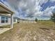 Large, fenced backyard with young trees, an AC unit, and a view of neighboring properties at 119 Summerlin Loop, Haines City, FL 33844