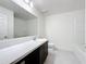 Bathroom vanity features a white marble countertop, sleek dark wood cabinets, and framed mirror at 119 Summerlin Loop, Haines City, FL 33844