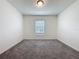 Bright, carpeted bedroom with a central window to let in natural light at 119 Summerlin Loop, Haines City, FL 33844