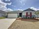 Charming single-story home with a two-car garage, red mulch, and well-maintained landscaping at 119 Summerlin Loop, Haines City, FL 33844