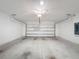 Empty two car garage with gray painted floor and an automatic garage door at 119 Summerlin Loop, Haines City, FL 33844
