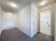 Hallway with carpet and tile flooring leads to the laundry room and a white front door at 119 Summerlin Loop, Haines City, FL 33844