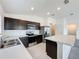 Well-lit kitchen with dark cabinets, stainless steel appliances, and an island with marble countertops at 119 Summerlin Loop, Haines City, FL 33844