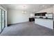 Open concept living space with bright kitchen featuring dark cabinets and stainless appliances, plus access to a patio at 119 Summerlin Loop, Haines City, FL 33844