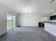 Bright living room and kitchen area featuring modern chandelier, outdoor patio access, and bright interior at 119 Summerlin Loop, Haines City, FL 33844