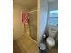 Bathroom featuring a glass-enclosed shower, toilet, and small window, providing natural light at 1211 Carey Glen Cir, Orlando, FL 32824