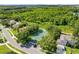 Aerial view featuring a tennis court with lush greenery and trees in a neighborhood at 13044 Lakeshore Grove Dr, Winter Garden, FL 34787