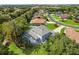 An elevated view of the home showcases a screened pool, manicured lawn, and mature trees at 13044 Lakeshore Grove Dr, Winter Garden, FL 34787