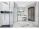 Bright bathroom with marble flooring, vanity and walk-in shower with gray accent tile and glass enclosure at 13044 Lakeshore Grove Dr, Winter Garden, FL 34787