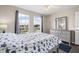 Bright bedroom featuring wood flooring, ceiling fan, bed and a window overlooking a lake at 13044 Lakeshore Grove Dr, Winter Garden, FL 34787