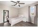 Bedroom with wood-look flooring, natural light, ceiling fan, and dark mirror at 13044 Lakeshore Grove Dr, Winter Garden, FL 34787