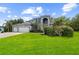 Lovely house with manicured landscaping, an arched entryway, and a three-car garage at 13044 Lakeshore Grove Dr, Winter Garden, FL 34787