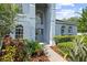 Charming home with a well-kept garden, leading to an inviting front entrance and elegant architectural details at 13044 Lakeshore Grove Dr, Winter Garden, FL 34787