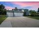 Elegant two-story home boasts a three-car garage and well-manicured lawn, reflecting sophisticated curb appeal at 13044 Lakeshore Grove Dr, Winter Garden, FL 34787