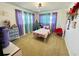 Cozy bedroom featuring colorful curtains, playful decorations, and a comfortable bed, creating an inviting space at 1419 Avenue D Ne, Winter Haven, FL 33881
